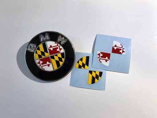 Overlay sticker that covers BMW emblem with Maryland (USA) flag image.  We only sell the sticker not the emblem.
